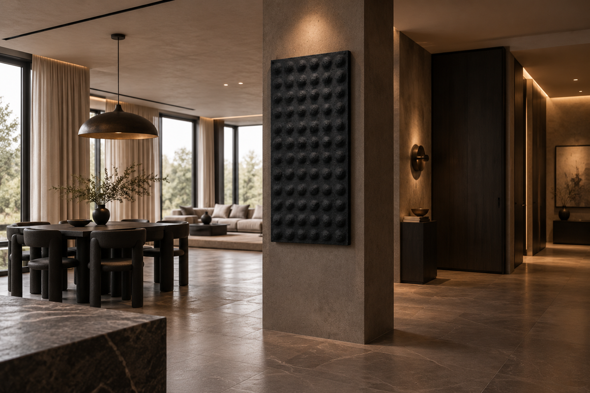 A single black sculptural wall panel mounted as a standalone piece on a stone wall in an open-plan dining and living space